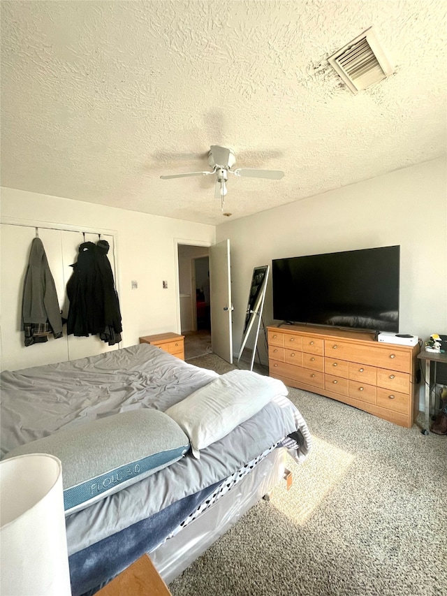 carpeted bedroom with a textured ceiling and ceiling fan