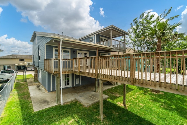 rear view of property with a deck and a lawn