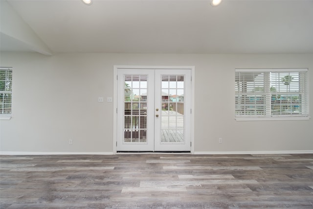 entryway featuring a healthy amount of sunlight, dark hardwood / wood-style floors, french doors, and lofted ceiling