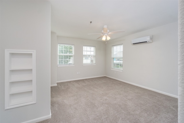 carpeted empty room featuring an AC wall unit, built in features, and ceiling fan