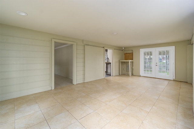 spare room featuring french doors and light tile floors