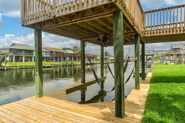 dock area featuring a water view and a lawn