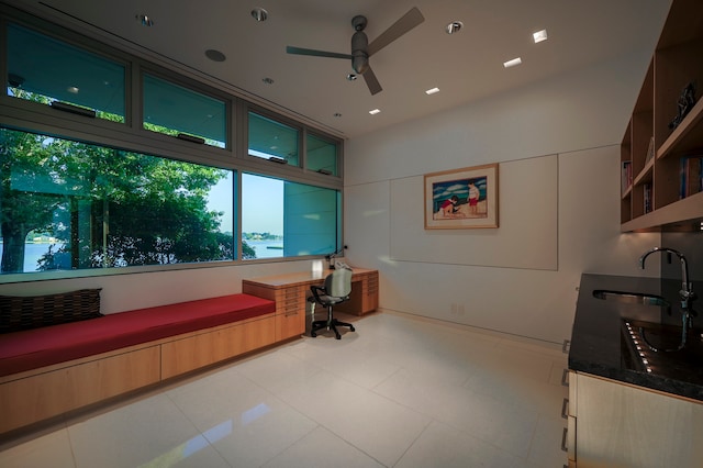 tiled office featuring ceiling fan and sink