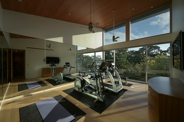 workout area with wooden ceiling, plenty of natural light, ceiling fan, and a high ceiling