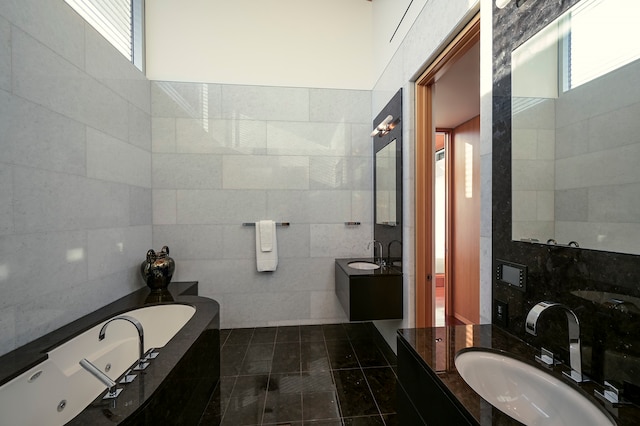 bathroom with tile walls, large vanity, a relaxing tiled bath, and tile floors