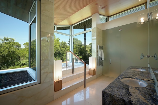 entryway featuring plenty of natural light, sink, light tile flooring, and a chandelier