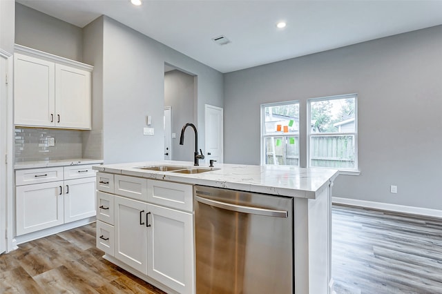 kitchen featuring light wood-type flooring, white cabinetry, an island with sink, sink, and stainless steel dishwasher