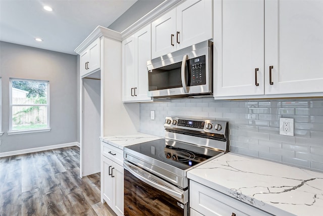 kitchen featuring light hardwood / wood-style flooring, stainless steel appliances, decorative backsplash, white cabinetry, and light stone counters