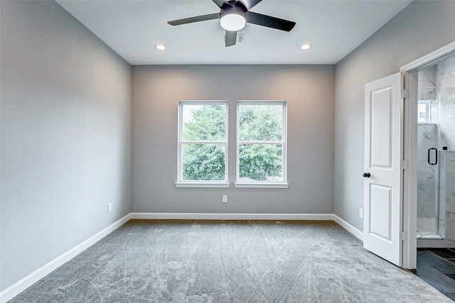 carpeted spare room featuring plenty of natural light and ceiling fan