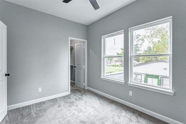 empty room featuring light colored carpet and ceiling fan