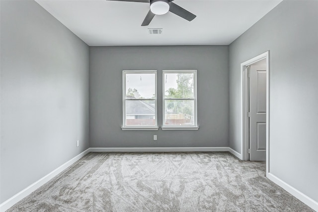 empty room featuring ceiling fan and light colored carpet