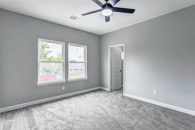 spare room featuring light colored carpet and ceiling fan