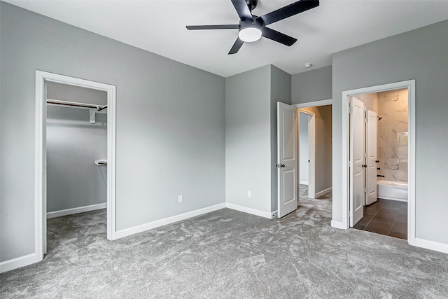 unfurnished bedroom featuring carpet, a walk in closet, ceiling fan, and connected bathroom