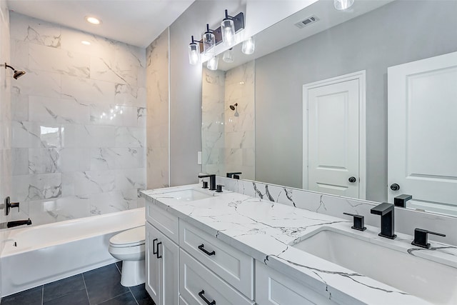 full bathroom featuring vanity, tiled shower / bath, tile patterned floors, and toilet