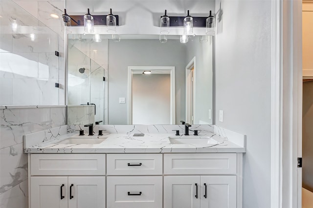 bathroom featuring a shower with shower door and vanity