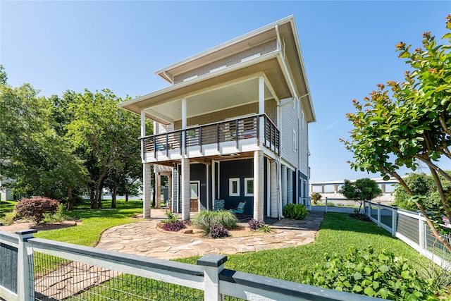 view of front of home with a balcony and a front lawn