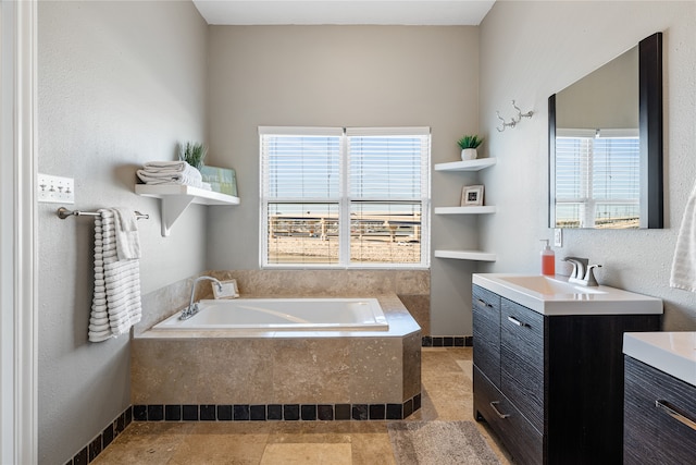 bathroom with vanity, tile patterned floors, tiled bath, and plenty of natural light