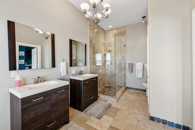 bathroom featuring tile patterned flooring, a notable chandelier, dual bowl vanity, an enclosed shower, and toilet