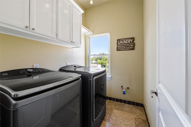 clothes washing area featuring separate washer and dryer, cabinets, and dark tile patterned flooring