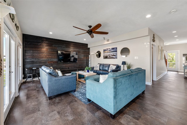 living room featuring wood walls and ceiling fan