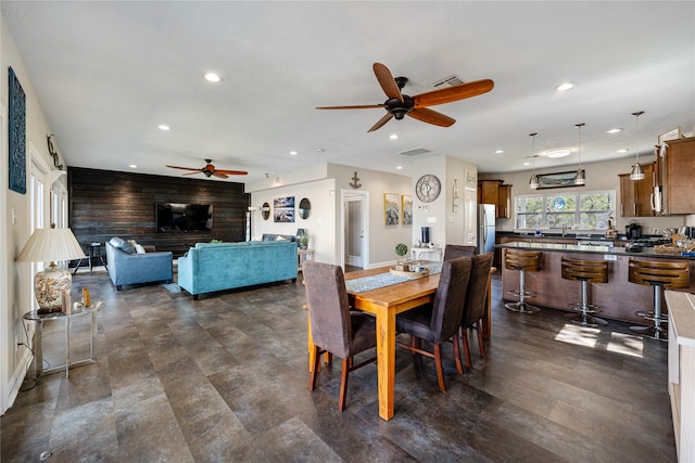 tiled dining area featuring wooden walls and ceiling fan