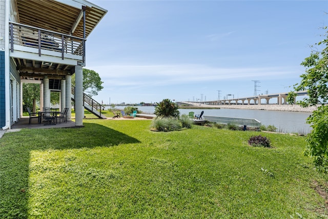 view of yard with a balcony, a water view, and a patio