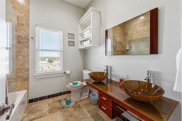 full bathroom featuring dual vanity, tile patterned flooring, tiled shower / bath combo, and toilet