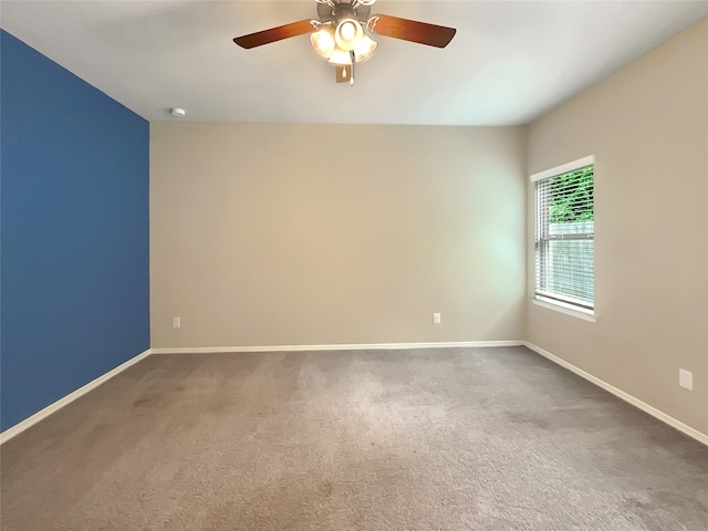 spare room with dark colored carpet and ceiling fan