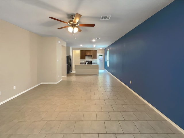 unfurnished living room with ceiling fan and light tile flooring