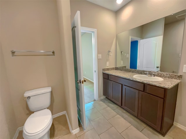 bathroom with vanity, toilet, and tile flooring