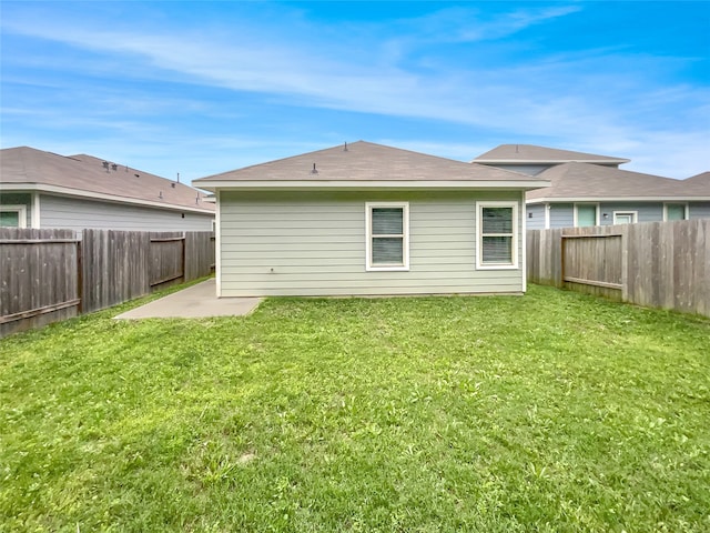 back of house with a patio and a lawn