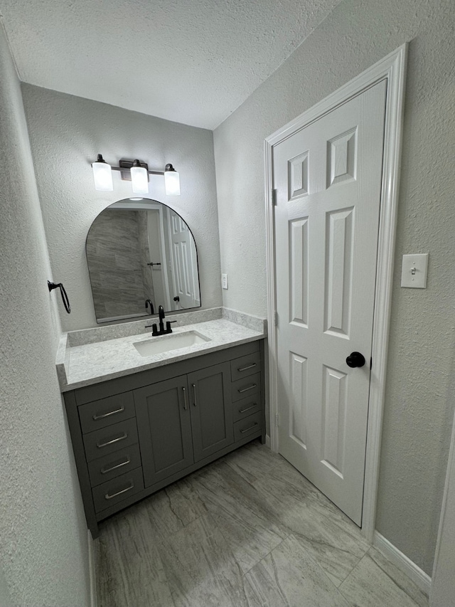 bathroom featuring tile flooring, a textured ceiling, and vanity