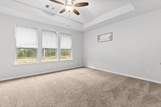 unfurnished room featuring ceiling fan, carpet flooring, and a raised ceiling