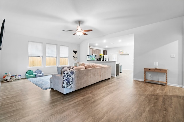 living room featuring dark wood-type flooring and ceiling fan