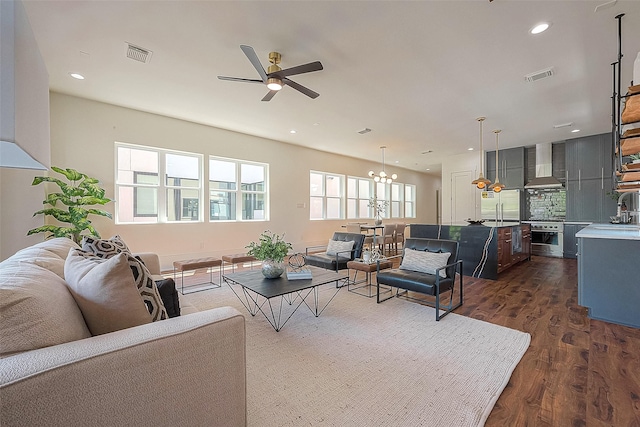 living room featuring dark hardwood / wood-style floors and ceiling fan with notable chandelier