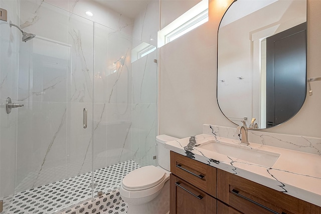 bathroom with vanity, toilet, and a shower with door