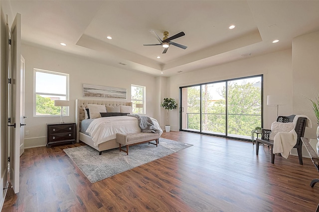 bedroom featuring a tray ceiling, ceiling fan, and dark wood-type flooring