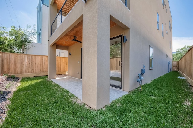 exterior space featuring a lawn, ceiling fan, and a patio