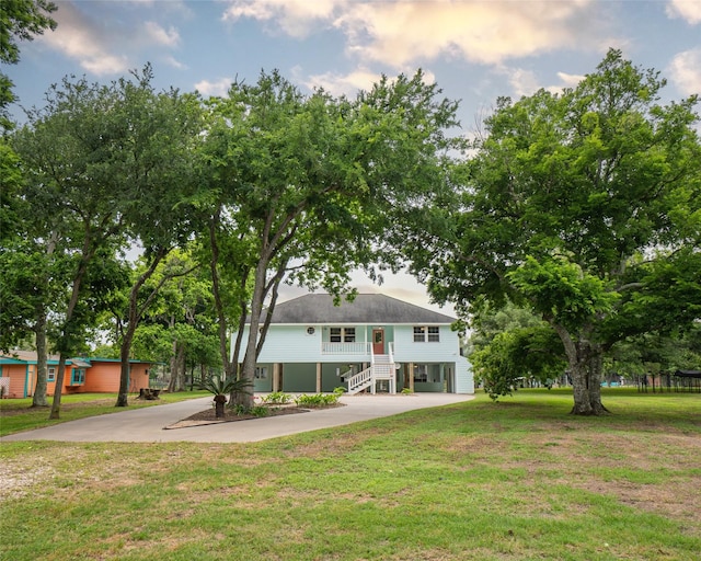 view of front of property with a carport, a front yard, driveway, and stairway