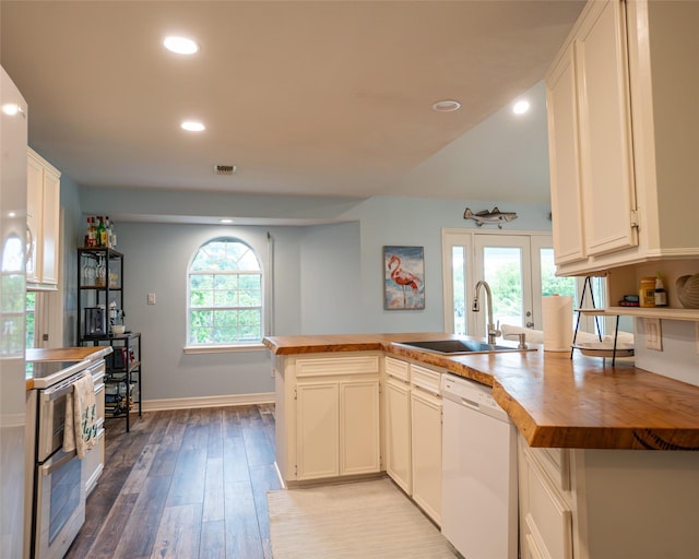 kitchen featuring dishwasher, white cabinets, sink, kitchen peninsula, and butcher block counters