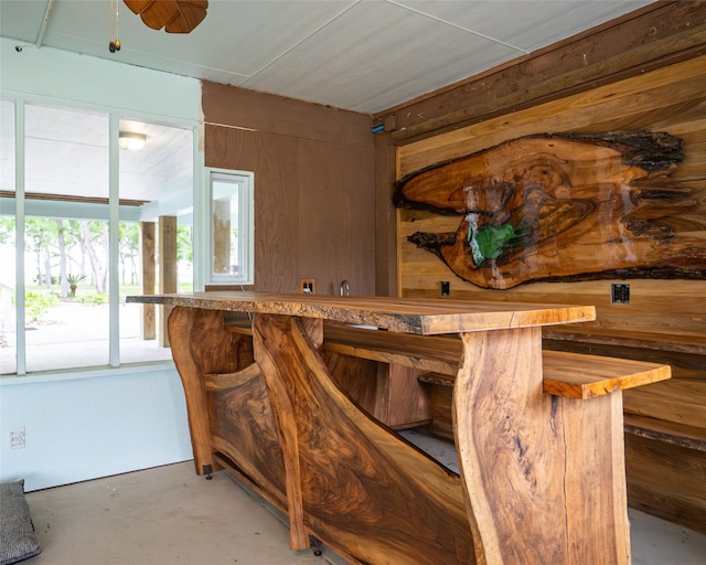 bar featuring ceiling fan and wooden walls