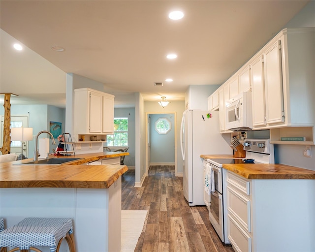 kitchen featuring wooden counters, white appliances, white cabinetry, and sink