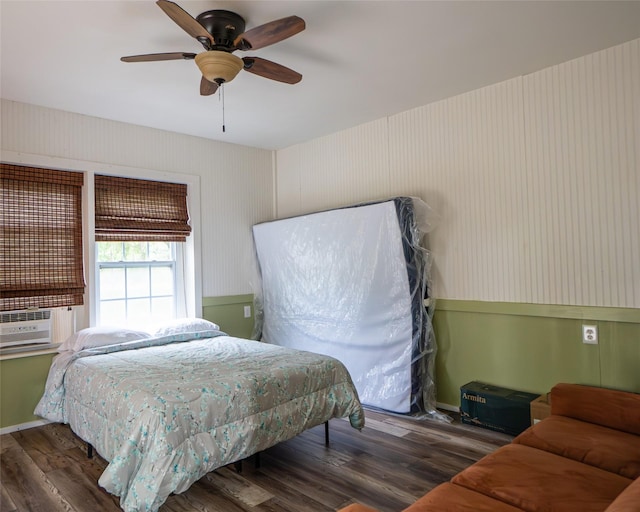 bedroom featuring dark hardwood / wood-style flooring, ceiling fan, and cooling unit