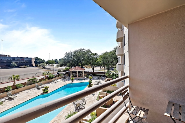 balcony featuring a community pool and a patio