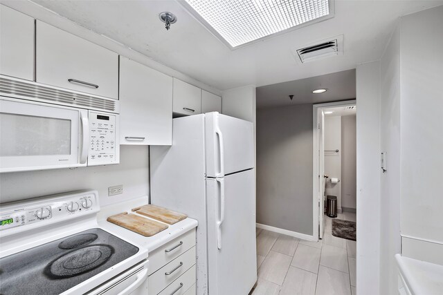 kitchen featuring white cabinets, white appliances, and light tile flooring