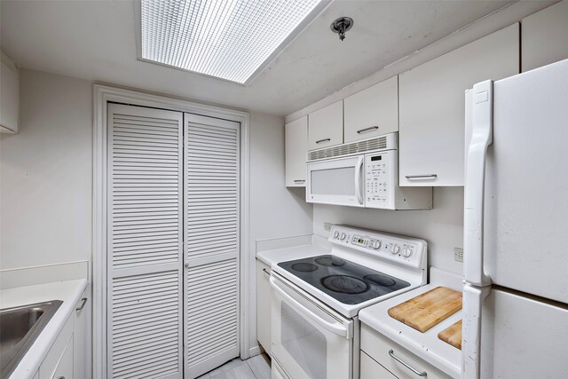 kitchen with white cabinets, white appliances, and sink