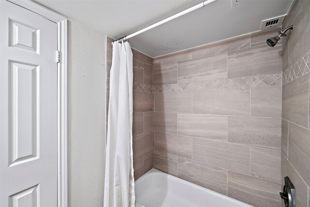 bathroom with shower / bath combo with shower curtain