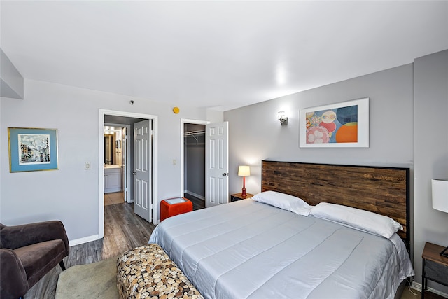 bedroom with a closet, dark wood-type flooring, and a walk in closet