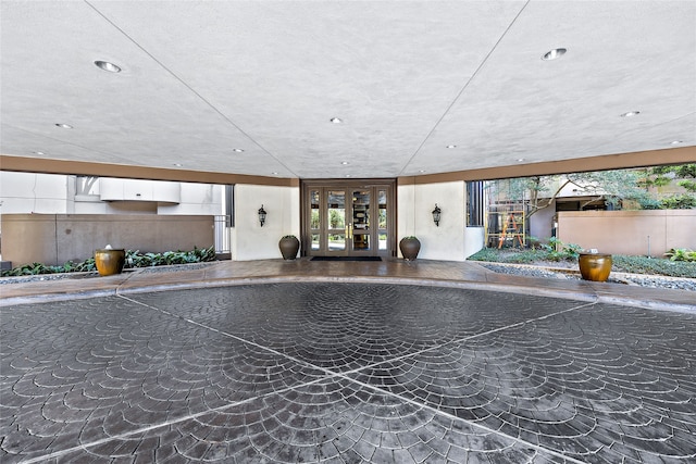 interior space with french doors and a textured ceiling