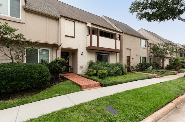 townhome / multi-family property with a front yard